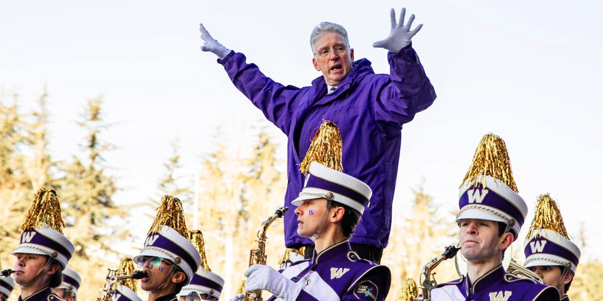 Brad McDavid conducts Husky Marching Band outside Husky Stadium