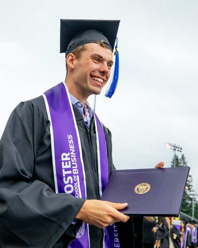 Max Head holding diploma in cap and gown